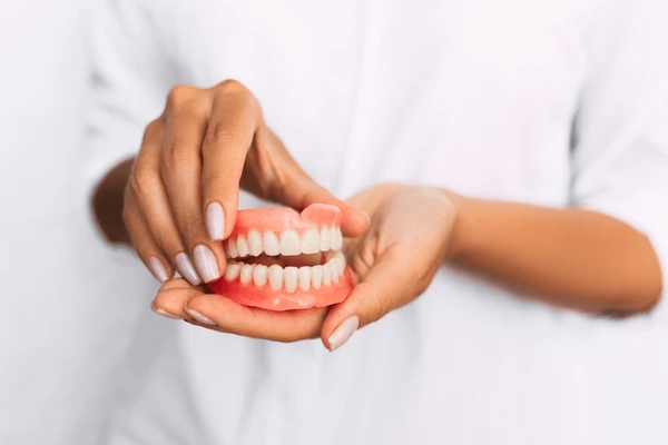 dentist-holding-dentures-his-hands