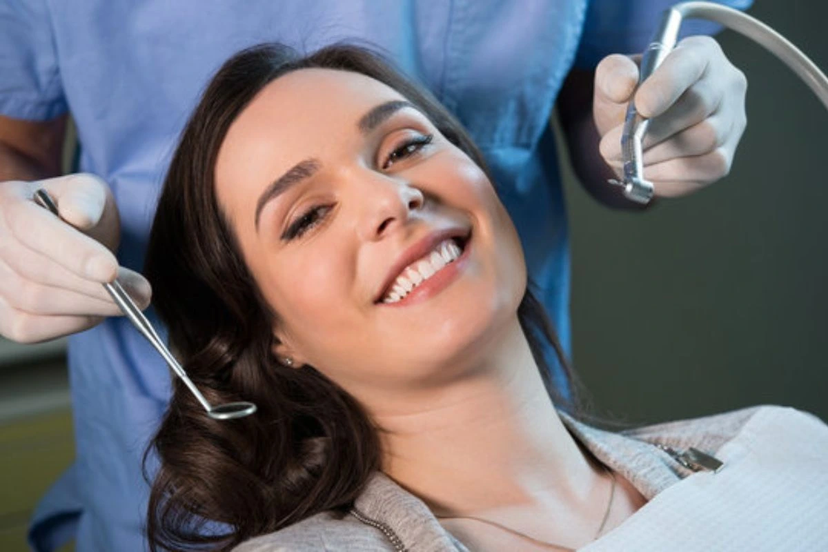 Happy patient at a dental clinic during a regular dental check up receiving care from a friendly dentist